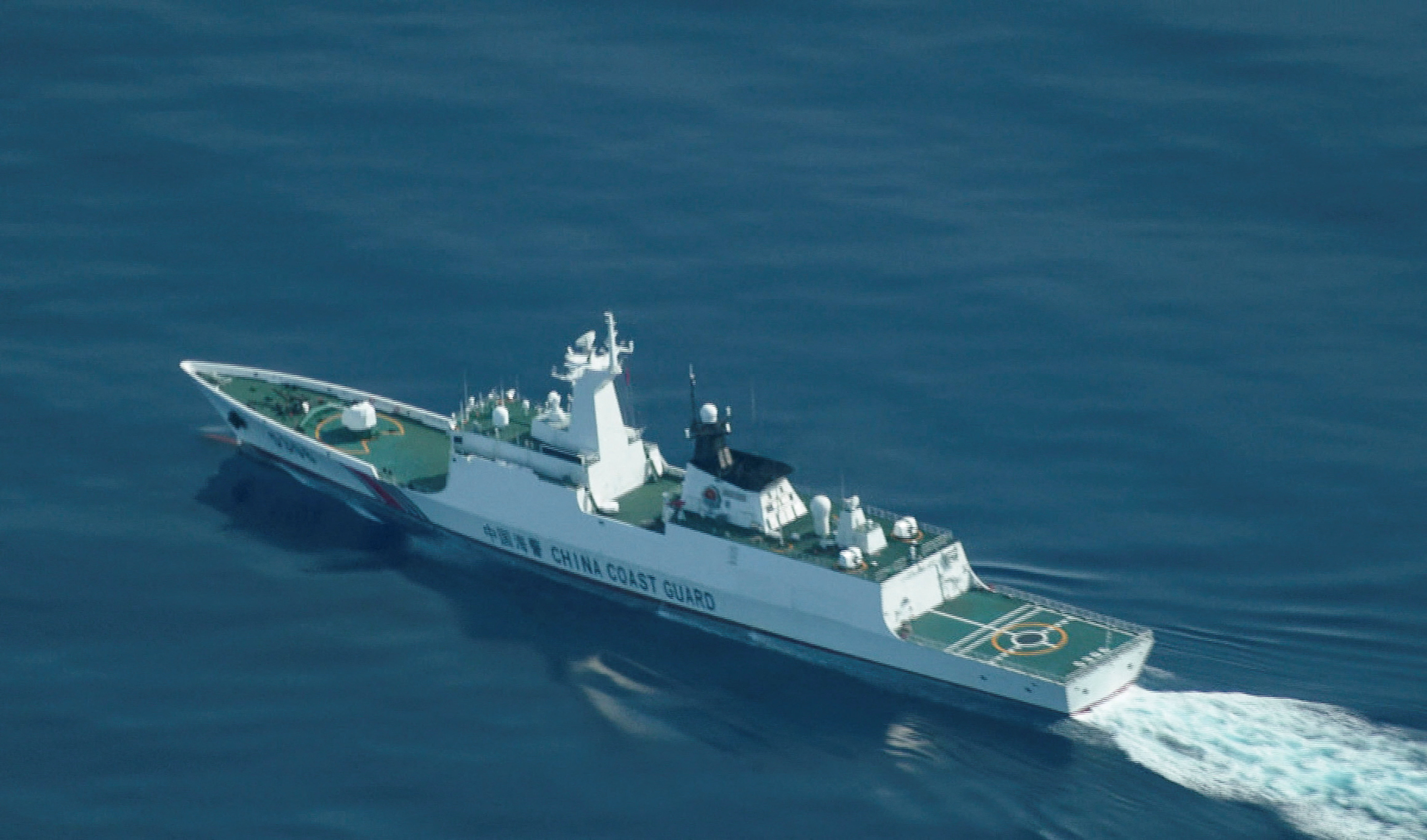 An aerial view of a China Coast Guard ship navigating near the disputed Scarborough Shoal, as Philippine Coast Guard aircraft carrying journalists patrols the area