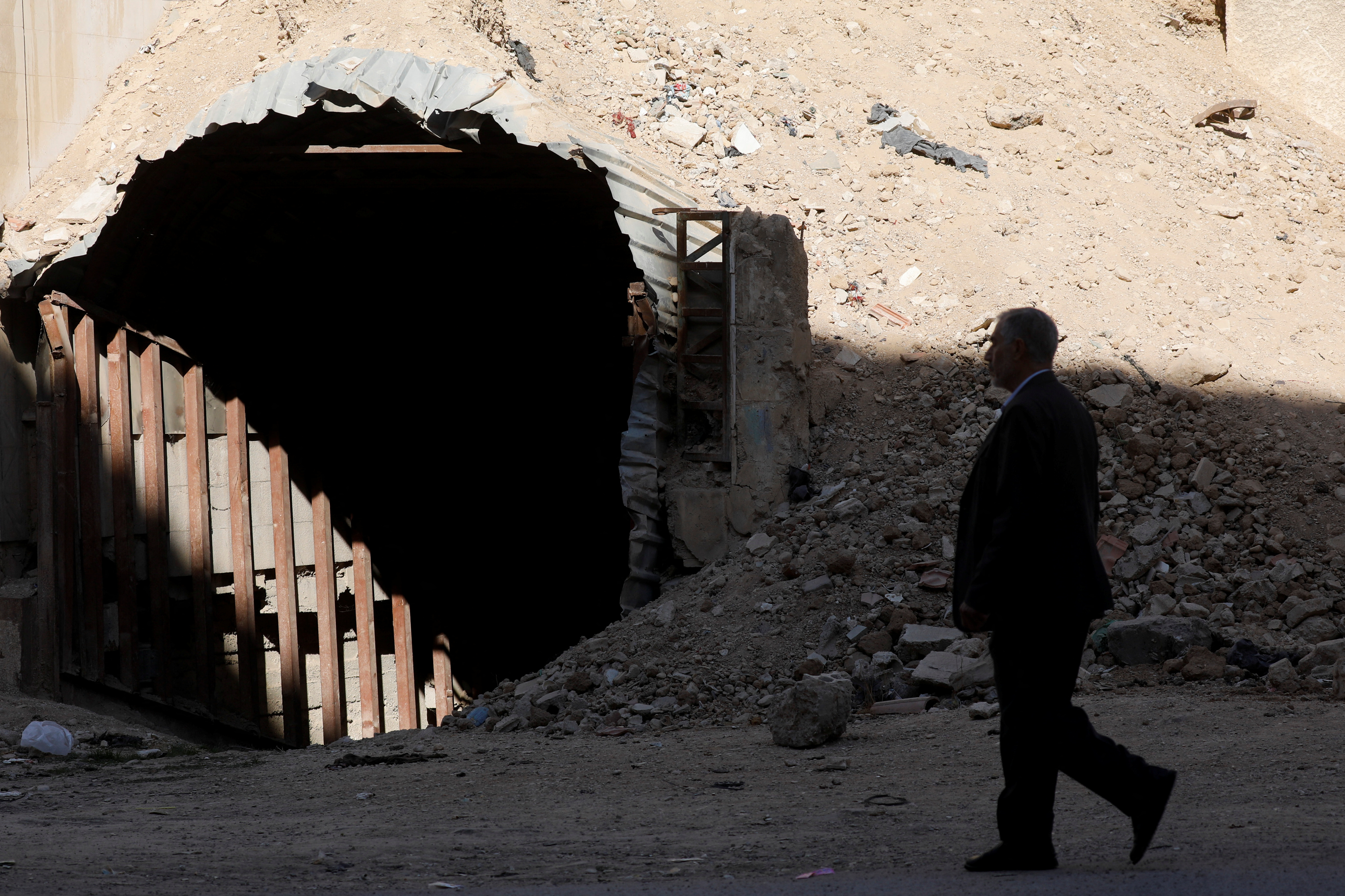 Man walks past a shelter used by residents to protect themselves from attacks in Douma, where a suspected chemical attack took place in 2018 under the rule of Syria's Bashar al-Assad