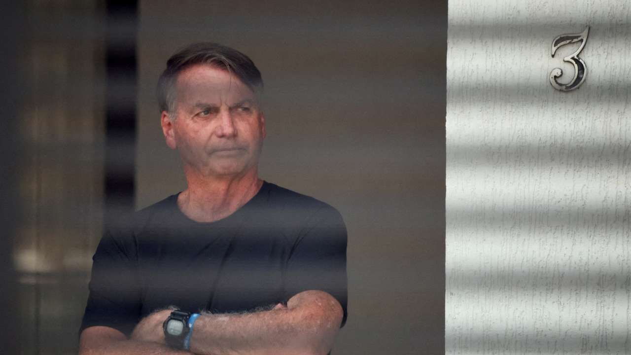 FILE PHOTO: Brazil’s former President Jair Bolsonaro stands at his home while under house arrest, in Brasilia