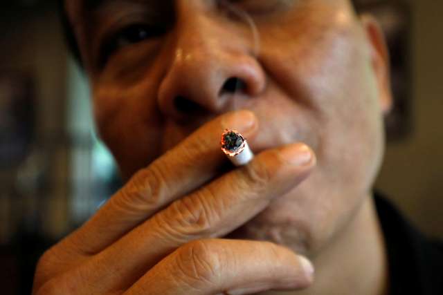 A man smokes at a cafe in Hanoi