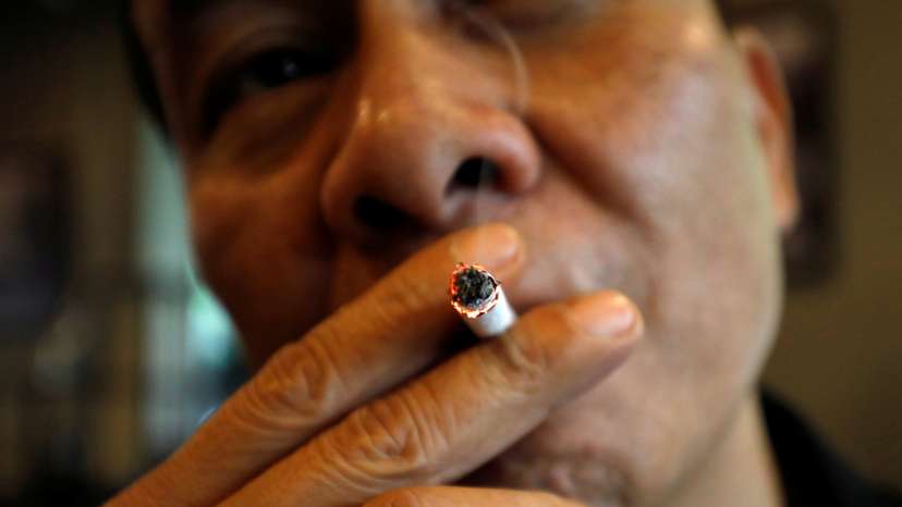 A man smokes at a cafe in Hanoi
