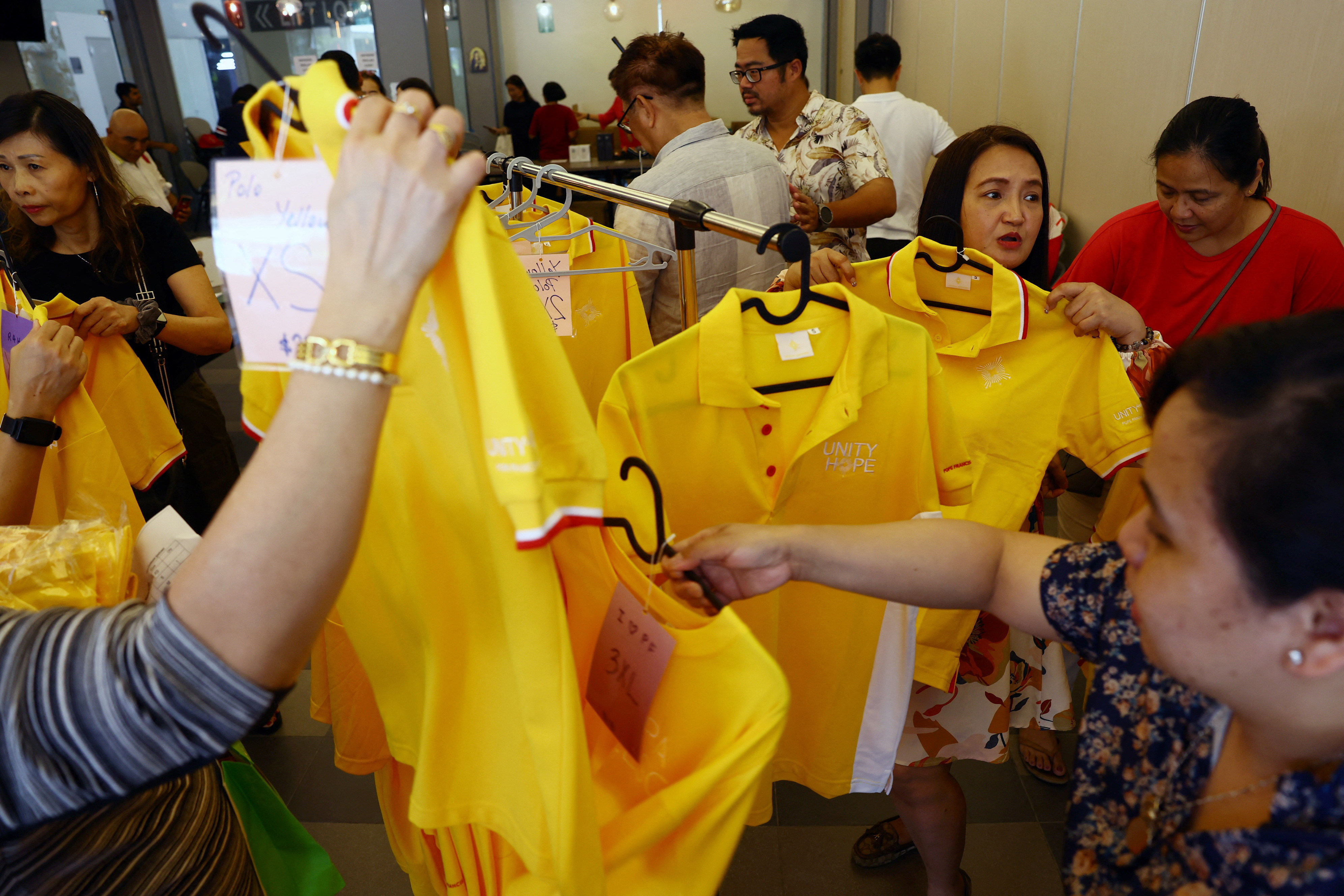 People shop for official souvenirs of the papal visit at Church of St Mary of the Angels in Singapore