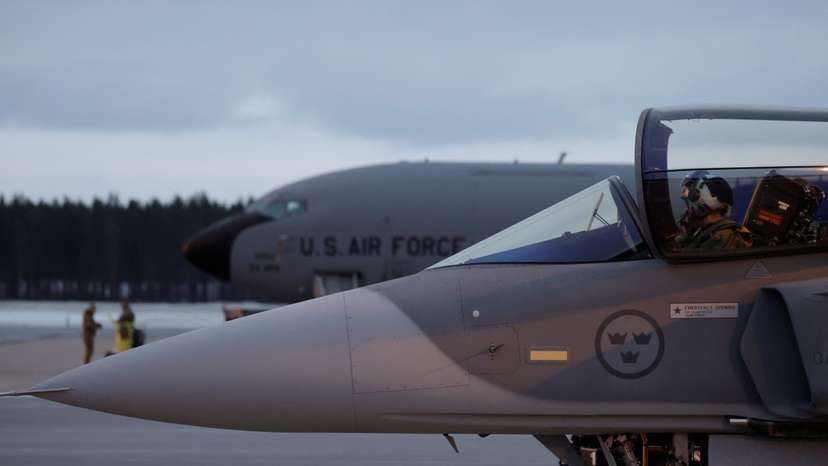 A Swedish JAS Gripen fighter jet stands next to an U.S. plane at Kallax Air Base