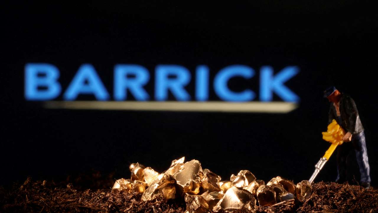 FILE PHOTO: Small toy figure and gold imitation are seen in front of the Barrick logo in this illustration