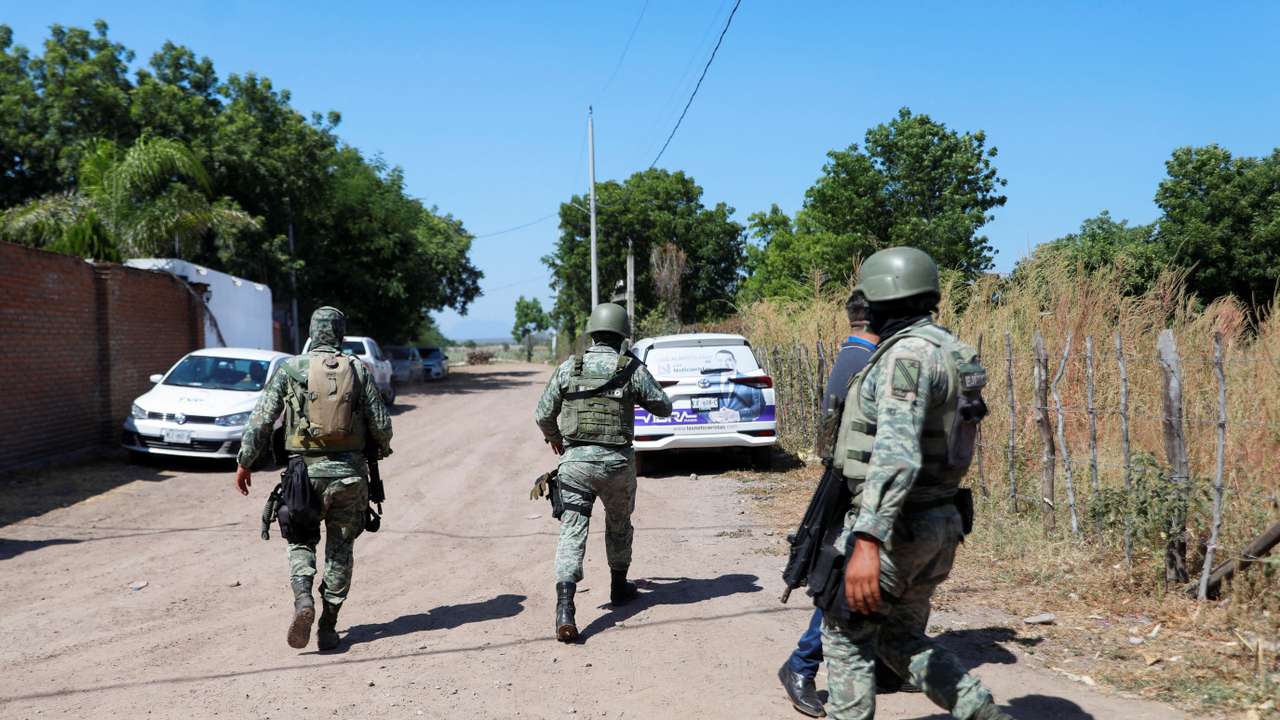 Federal forces guard the perimeter of a scene following a shootout, in Culiacan