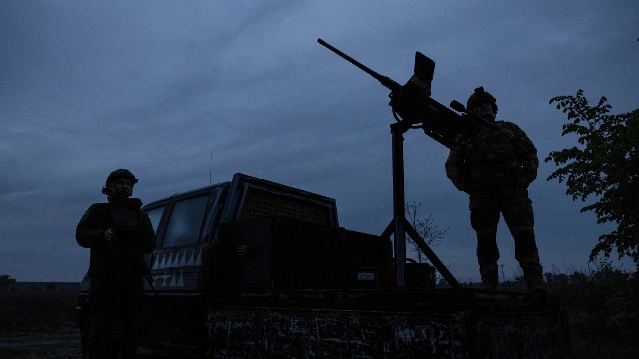 Members of a mobile air defence volunteer unit stand next to their machine gun during the most massive Russian drone attack in Kyiv region