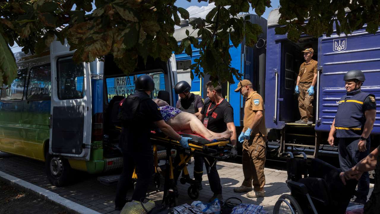 Volunteers of East SOS evacuate a woman, as Russian forces advance across the frontlines in the Donetsk region, at the train station in Pokrovsk