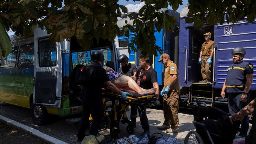Volunteers of East SOS evacuate a woman, as Russian forces advance across the frontlines in the Donetsk region, at the train station in Pokrovsk