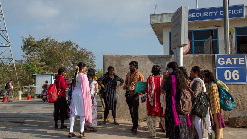 Job aspirants talk with a hiring agent outside the Foxconn plant in Sriperumbudur