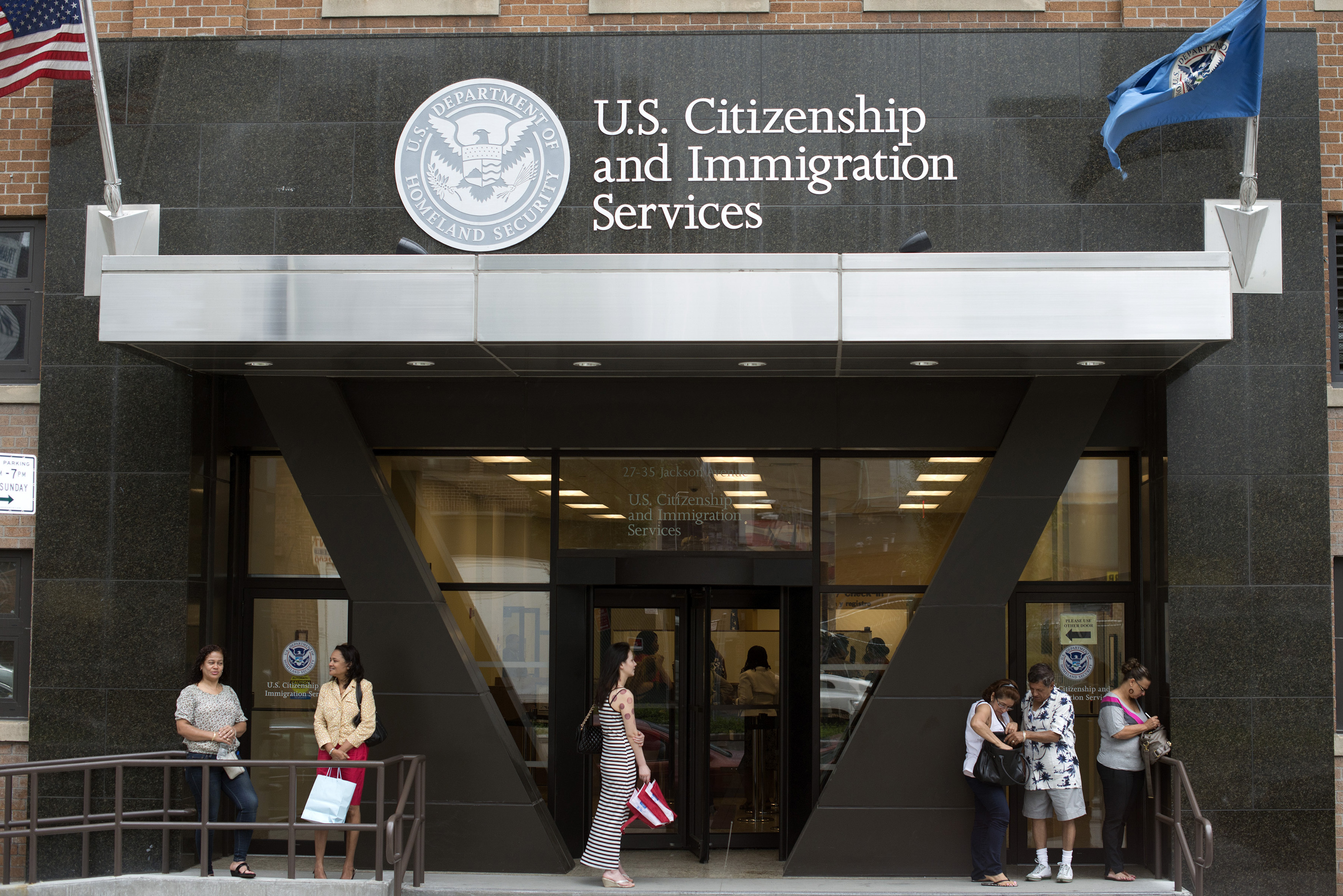 FILE PHOTO: People stand on the steps of the U.S. Citizenship and Immigration Services offices in New York
