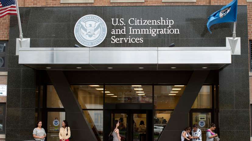 FILE PHOTO: People stand on the steps of the U.S. Citizenship and Immigration Services offices in New York