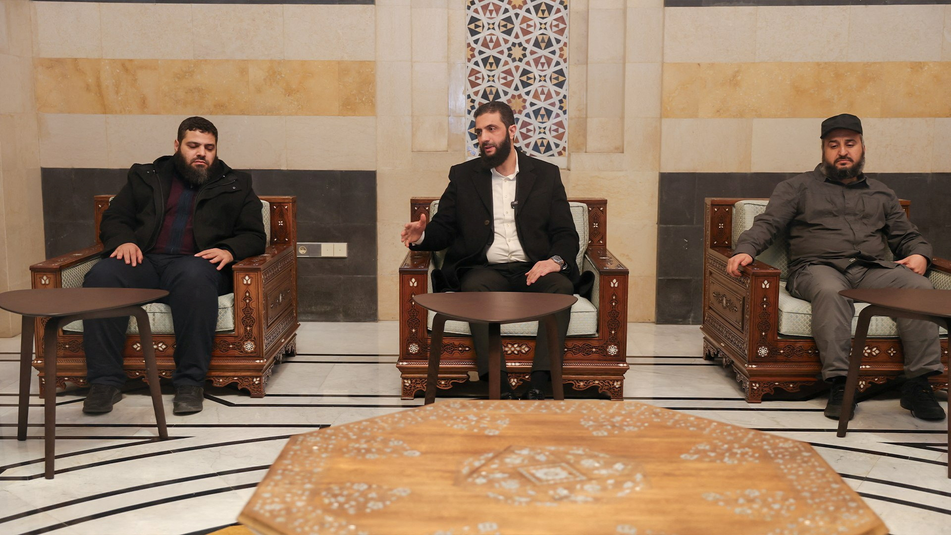 Head of Hayat Tahrir al-Sham and Syria's de facto leader, Ahmed al-Sharaa sits next to Murhaf Abu Qasra, who according to an official source has been appointed as defense minister in Syria's interim government, in Damascus, Syria