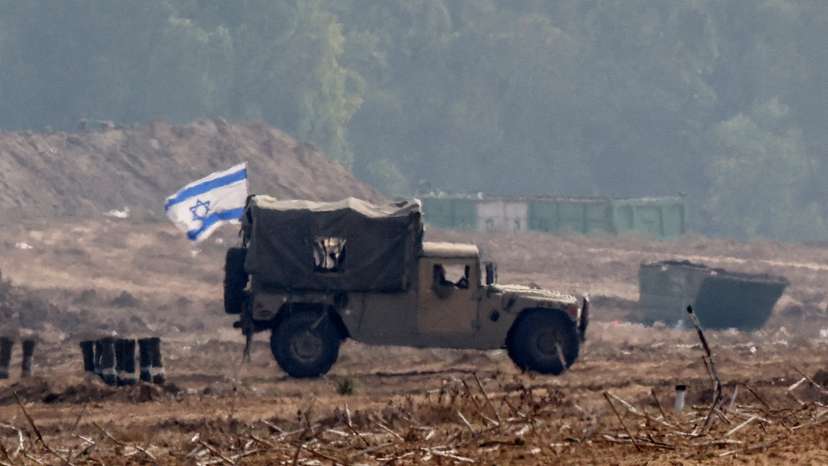 Israeli military vehicles operate at the border with Gaza as seen from southern Israel