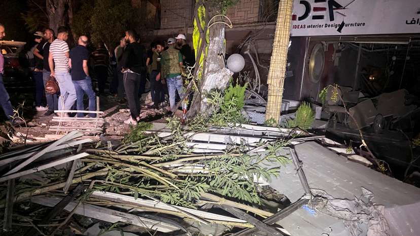 People gather near the site of an Israeli airstrike, in Damascus