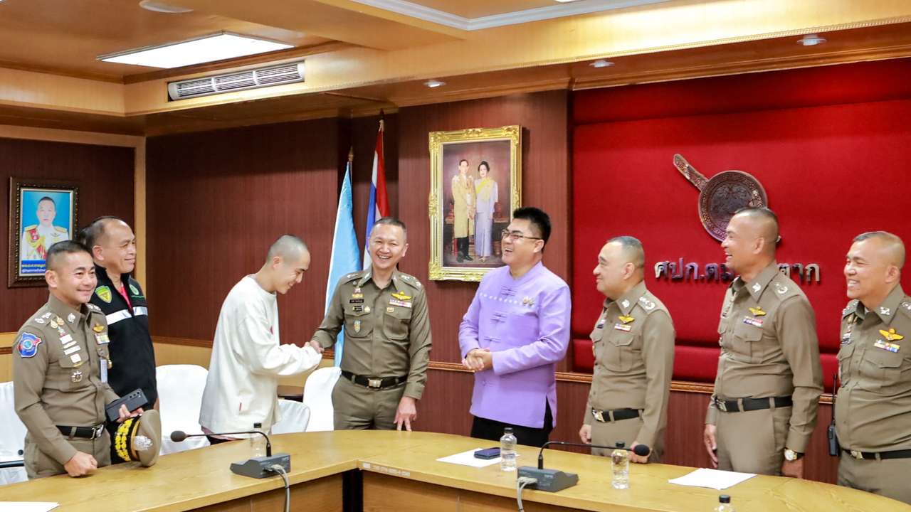 Chinese actor Wang Xing shakes hand with police officer after being assisted in his return to the country after being kidnapped