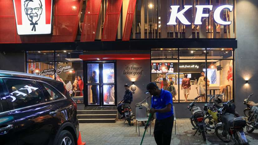 A worker clears the floor at the Kentucky Fried Chicken (KFC) fast food outlet, in Karachi