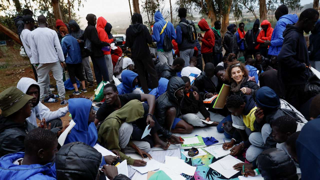 Several volunteers give Spanish classes to migrants outside the Las Raices Camp in La Laguna