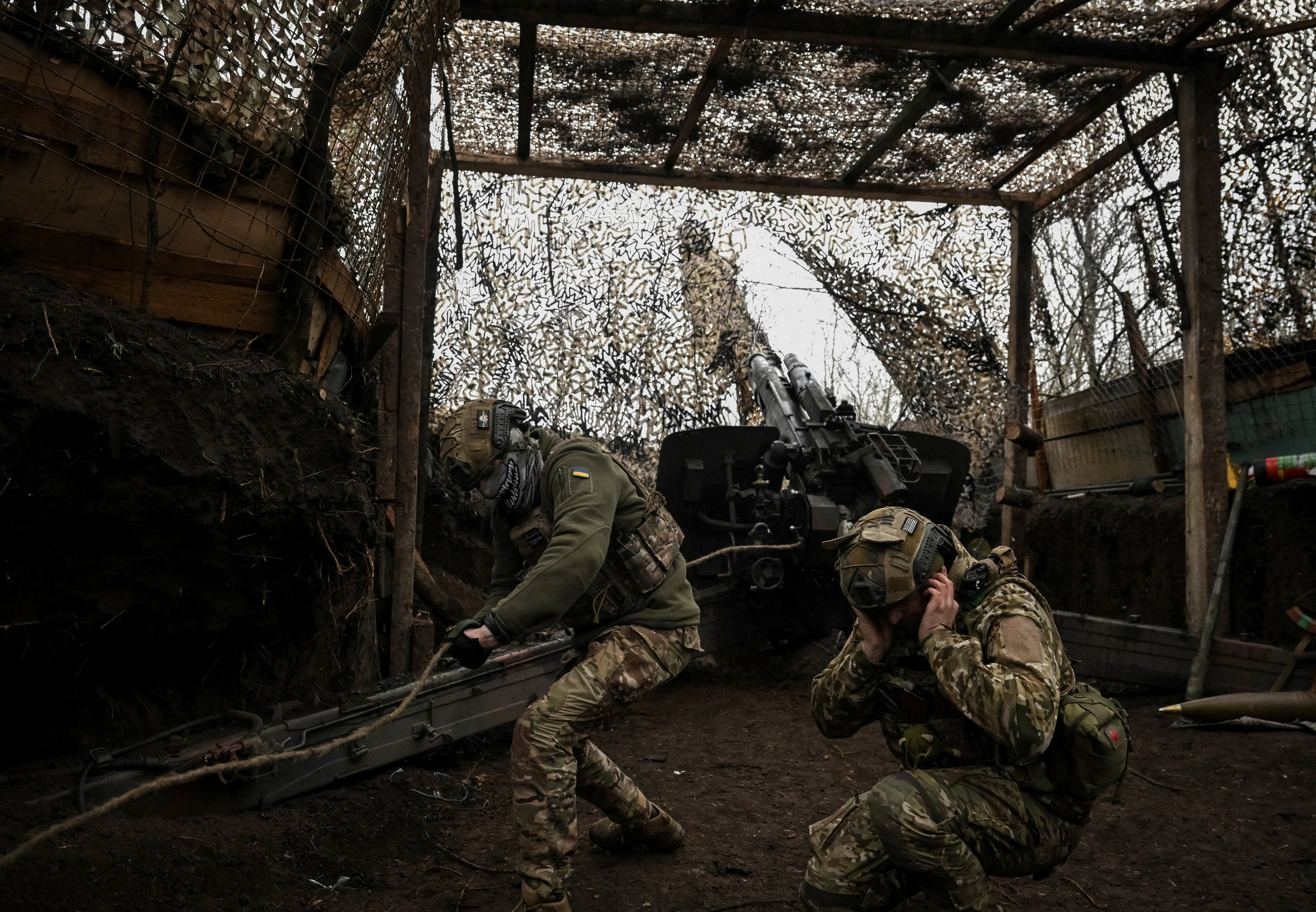 Ukrainian servicemen fire a howitzer towards Russian troops near the frontline town of Pokrovsk