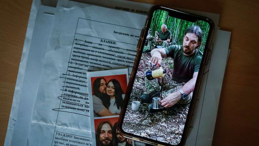 Photo of Ukrainian serviceman, who was declared missing-in-action in Donetsk region, is displayed on a phone of his wife, in Kyiv