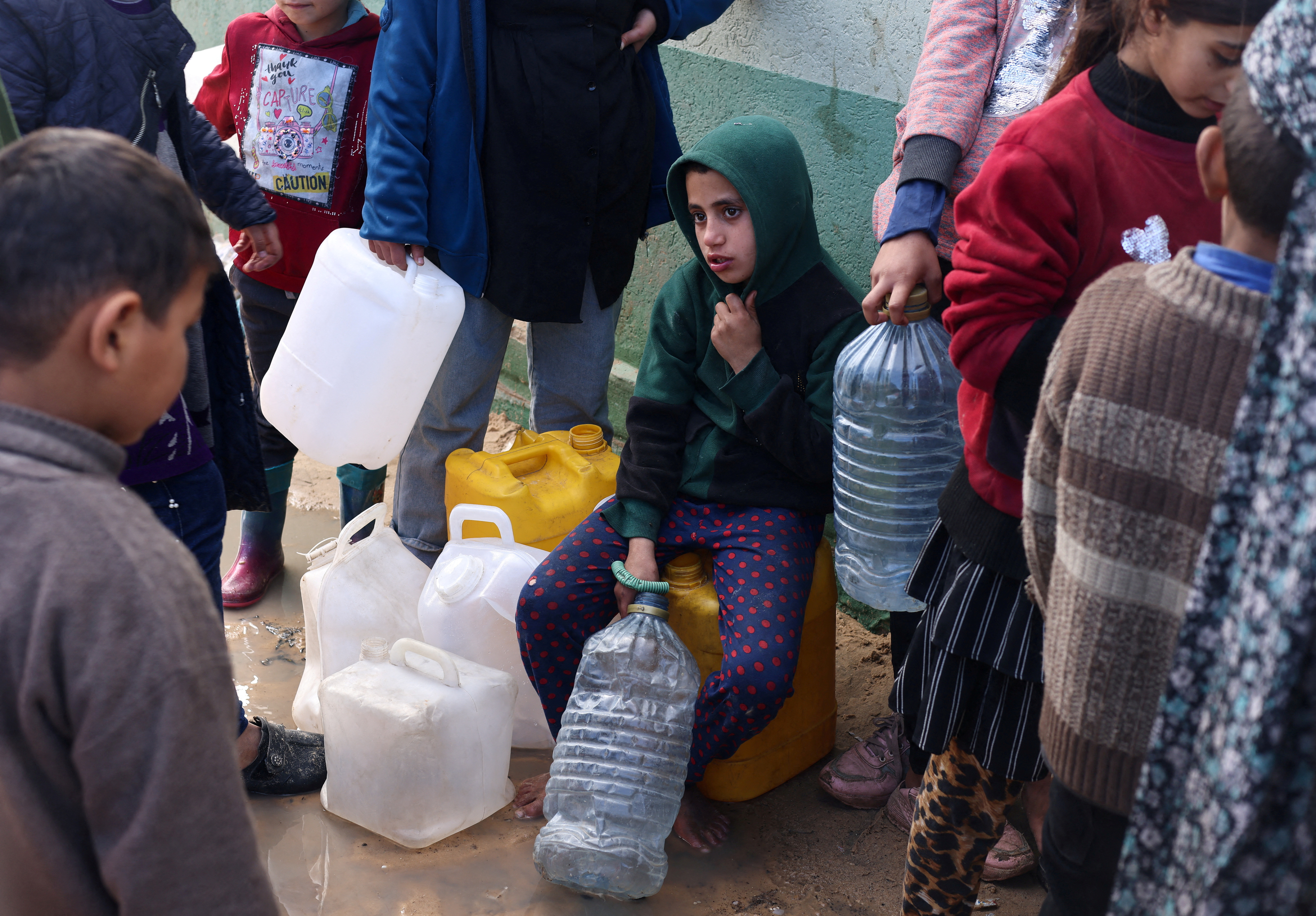 Palestinians wait to collect drinking water amid shortages, in Rafah