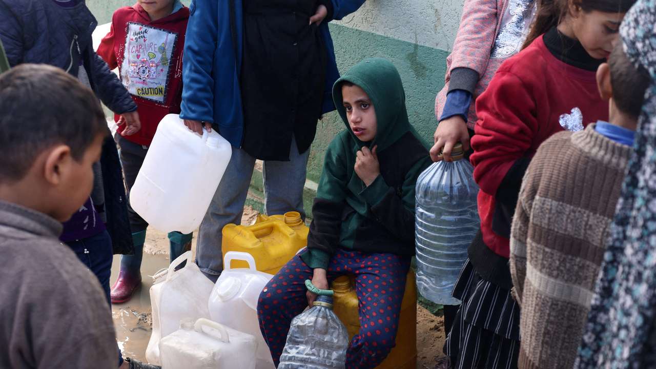 Palestinians wait to collect drinking water amid shortages, in Rafah