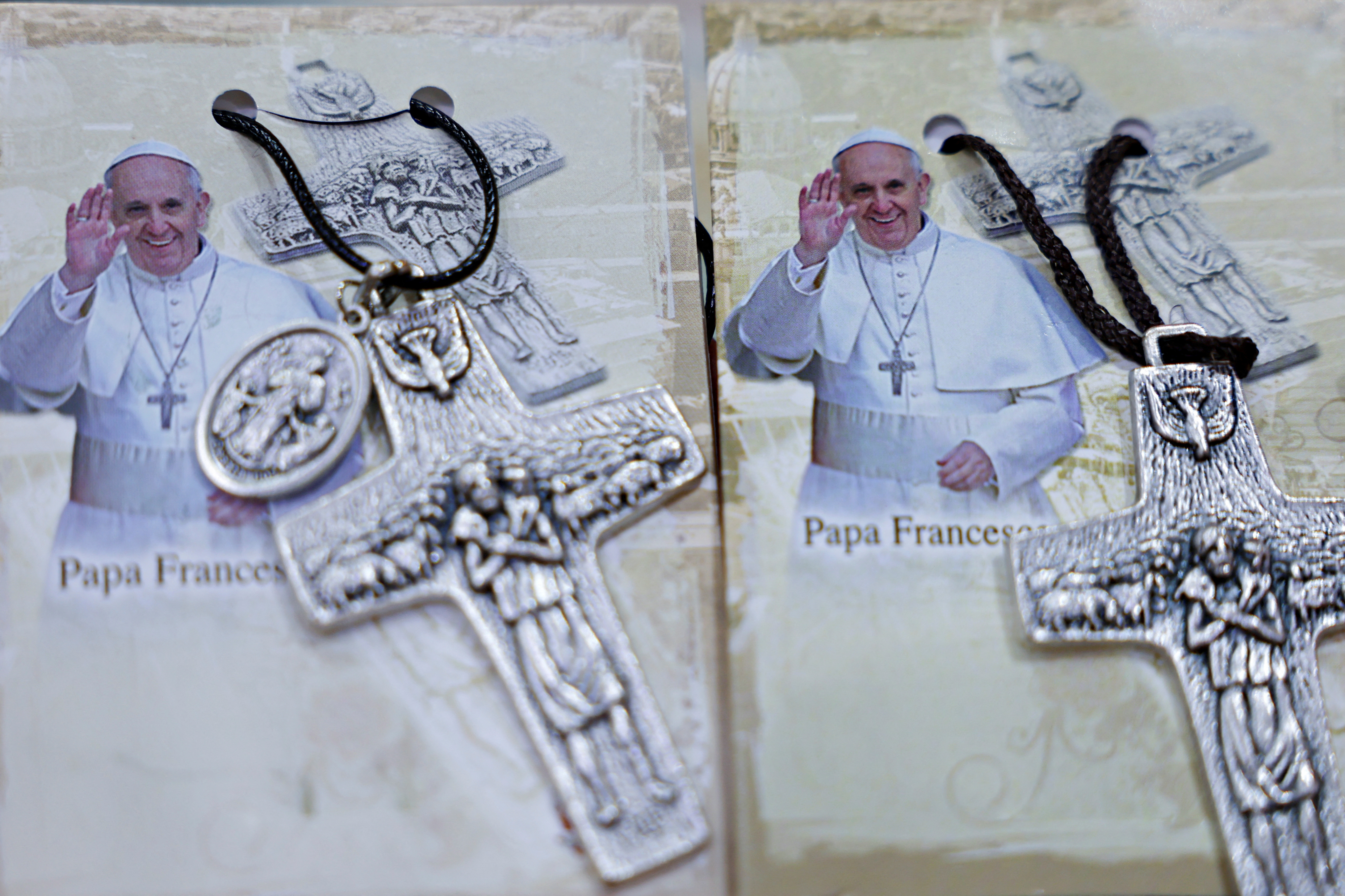 Photographs of Pope Francis are displayed beside crosses at the Avila store ahead of his visit, in Jakarta