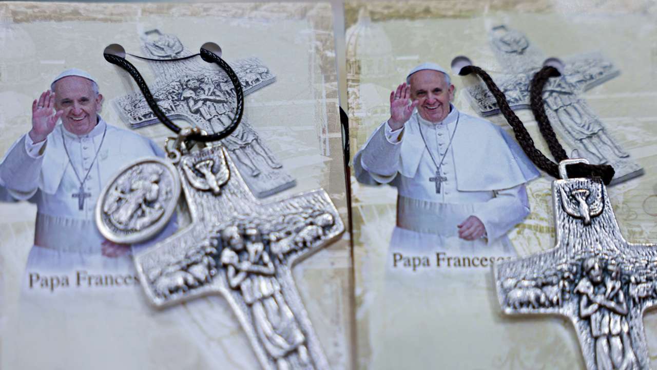 Photographs of Pope Francis are displayed beside crosses at the Avila store ahead of his visit, in Jakarta