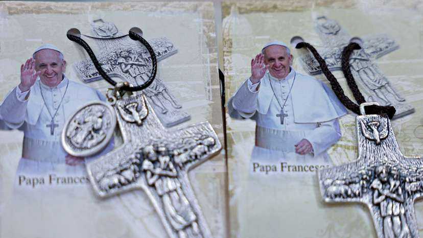 Photographs of Pope Francis are displayed beside crosses at the Avila store ahead of his visit, in Jakarta