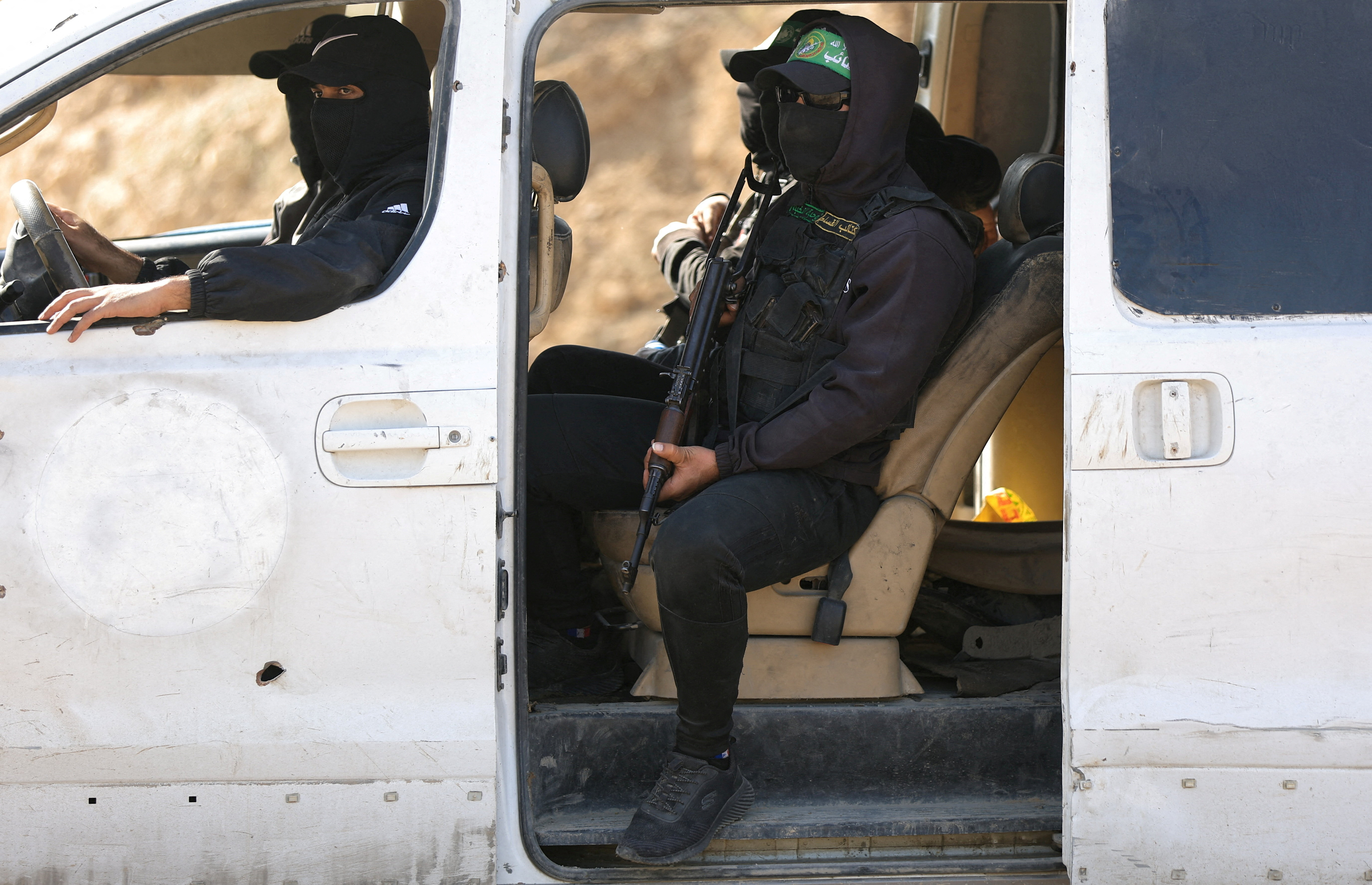Hamas militants escort members of the Red Cross towards an area within the so-called "yellow line", in Gaza City