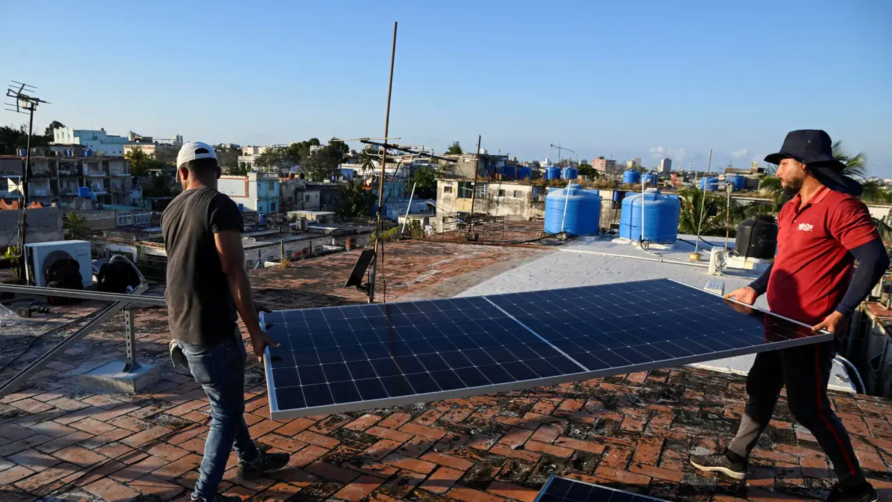 Solar panel technicians Denis Tamayo, 30, and Alejandro Guerra, 30, carry a solar panel on the rooftop of a building as Cubans grapple with an ongoing energy crisis exacerbated by fuel shortages, Havana, Cuba February 16, 2026. REUTERS/Norlys Pere