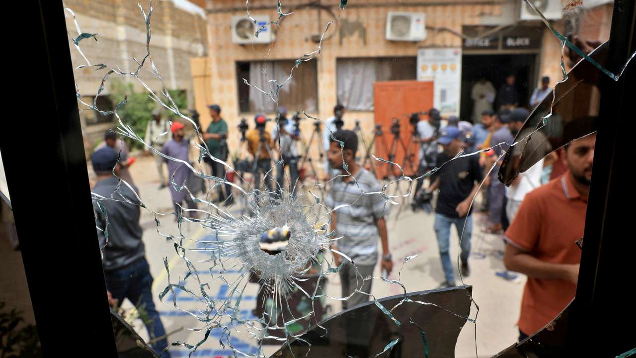Members of media are seen through a broken glass window inside the premises of the district Malir jail after dozens of prisoners escaped from the jail on the outskirts of Karachi