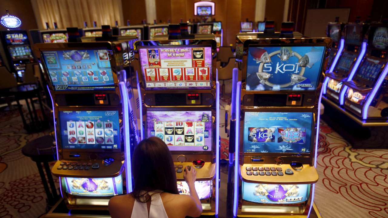 FILE PHOTO: A casino trainee demonstrates how to play a slot machine in the Philippines, April 16, 2015. REUTERS/Erik De Castro/File Photo