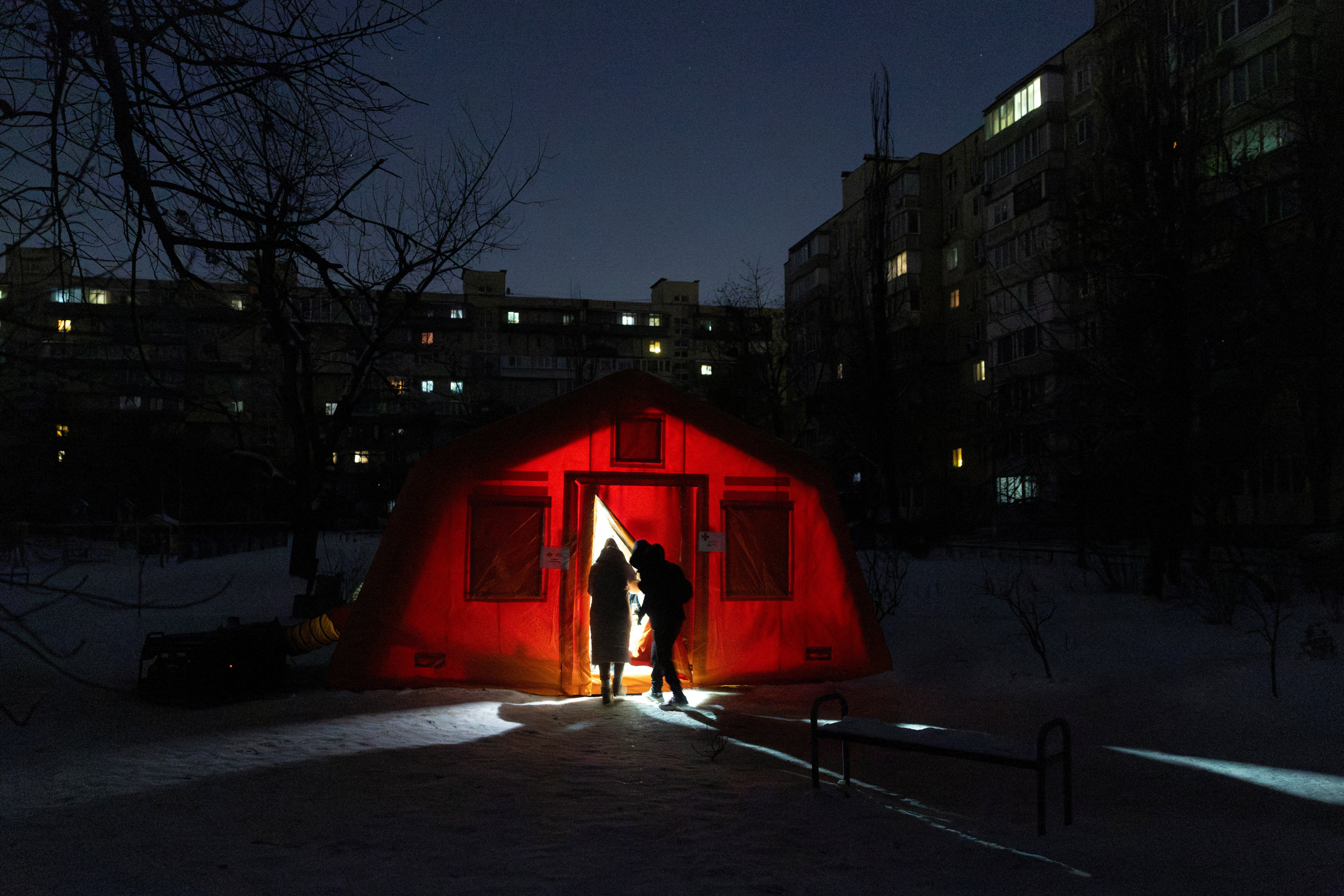 People enter a tent provided by emergency services for residents whose apartments are left without heating during sub-zero temperatures in Kyiv
