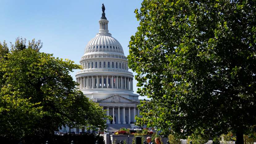 A woman and a man walk in front of the U.S. Capitol in Washington