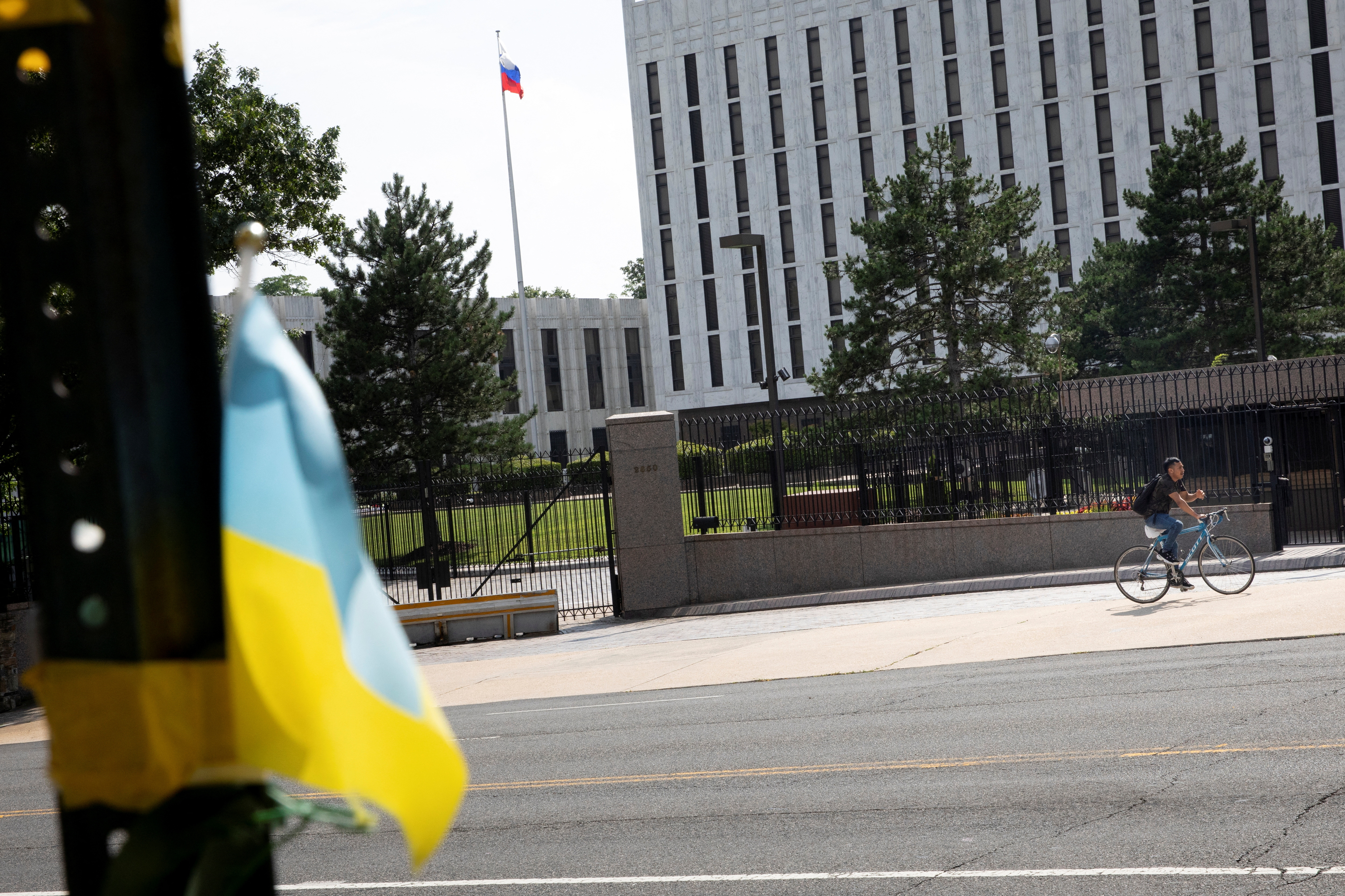 A pedestrian rides a bicycle outside the Russian Embassy in the Glover Park neighborhood in Washington