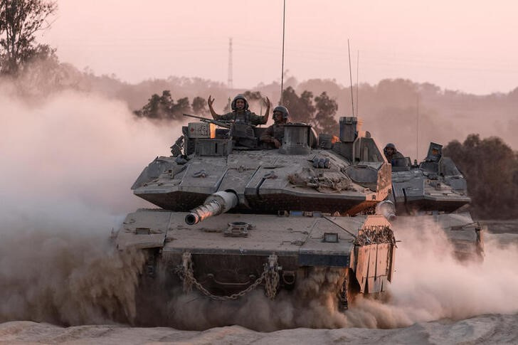 FILE PHOTO: An Israeli soldier gestures on a top of a tank, near the Israel-Gaza border