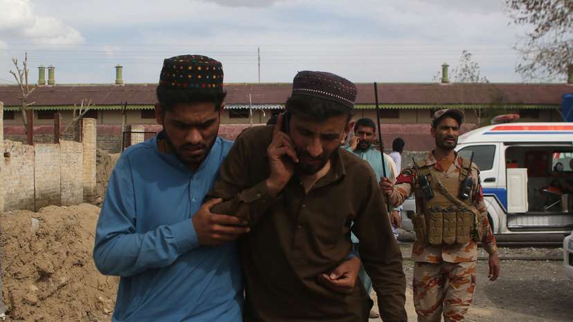 Plain clothes security force perosnnel, who were rescued from a train after it was attacked by separatist militants, leave Mach railway station in Mach
