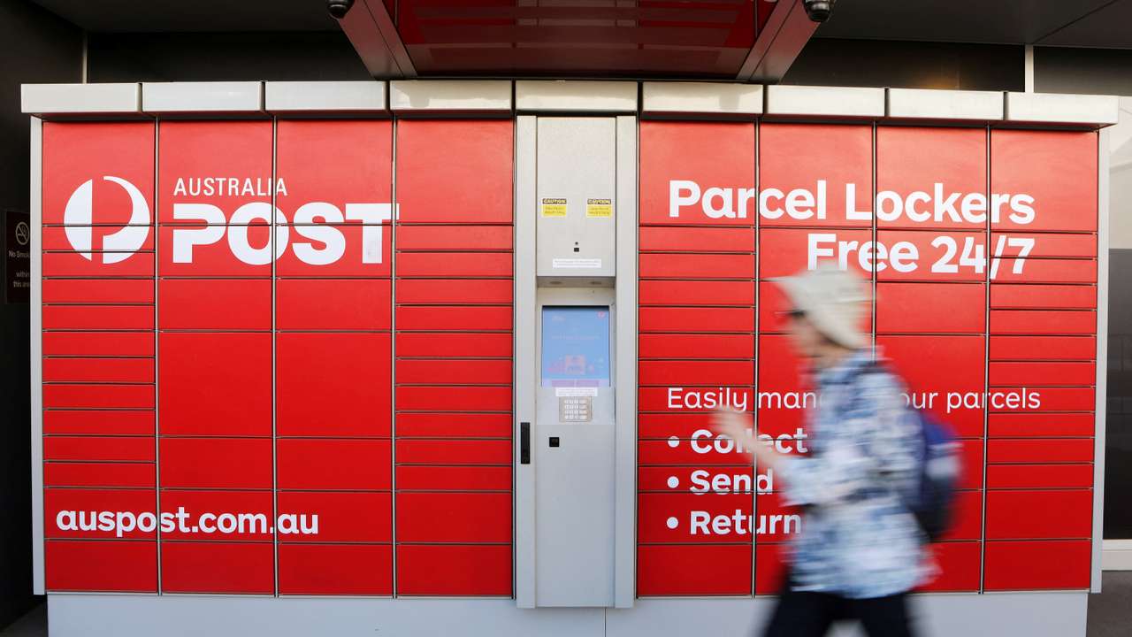 FILE PHOTO: A woman walks past Australia Post parcel lockers in Sydney