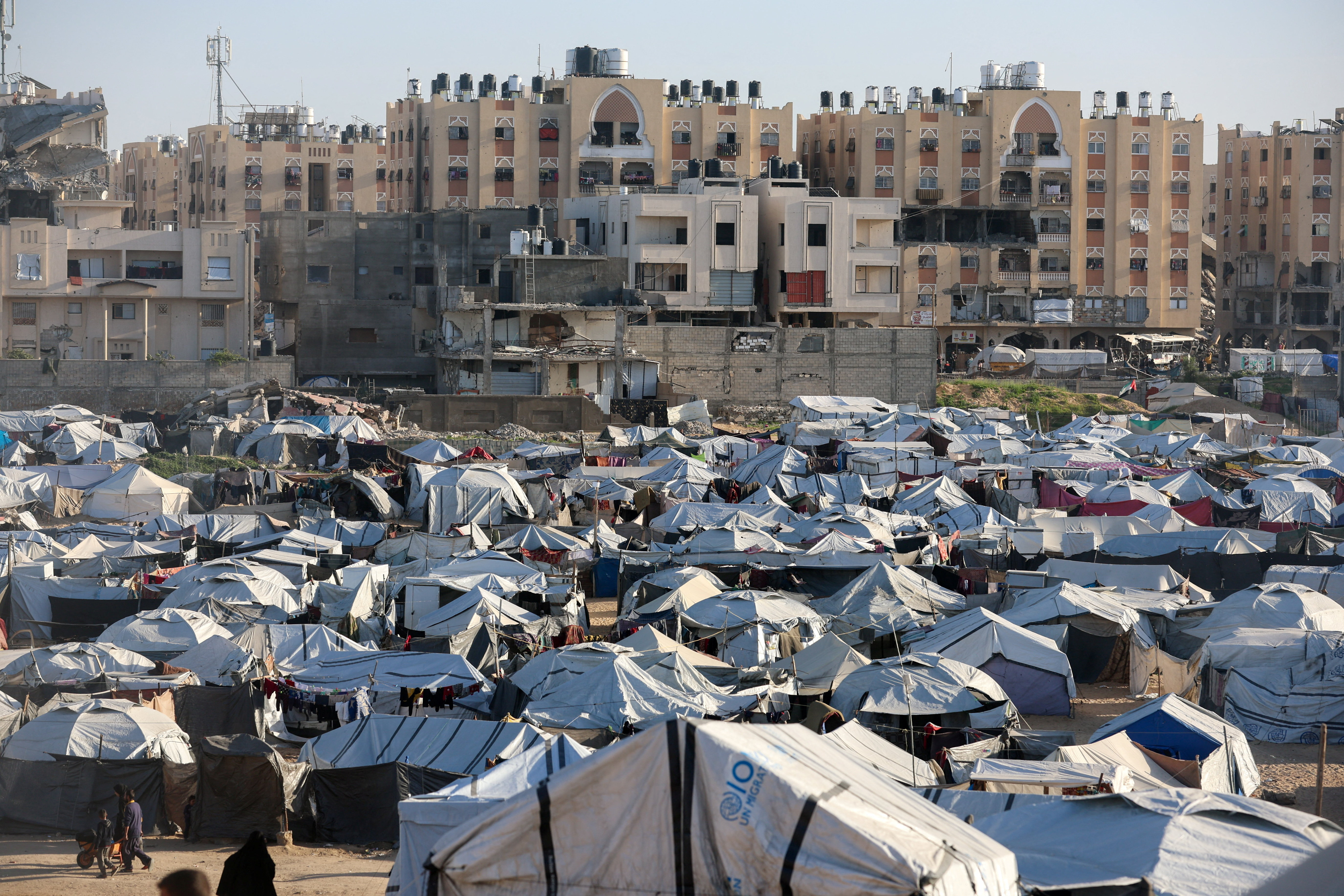 Palestinians displaced during the two-year Israeli offensive shelter at a tent camp in Khan Younis