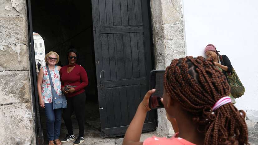 American tourist, Divine Koufahenou takes a picture of her Mother Afi and her friend Dawn Kravig at the 'Door of No Return' at the Cape Coast Slave Castle