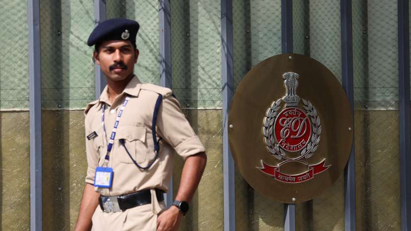 A security personnel walks past a gate of the office of Directorate of Enforcement in New Delhi