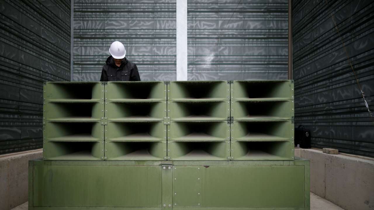 A worker dismantles loudspeakers that were set up for propaganda broadcasts near the demilitarized zone separating the two Koreas in Paju