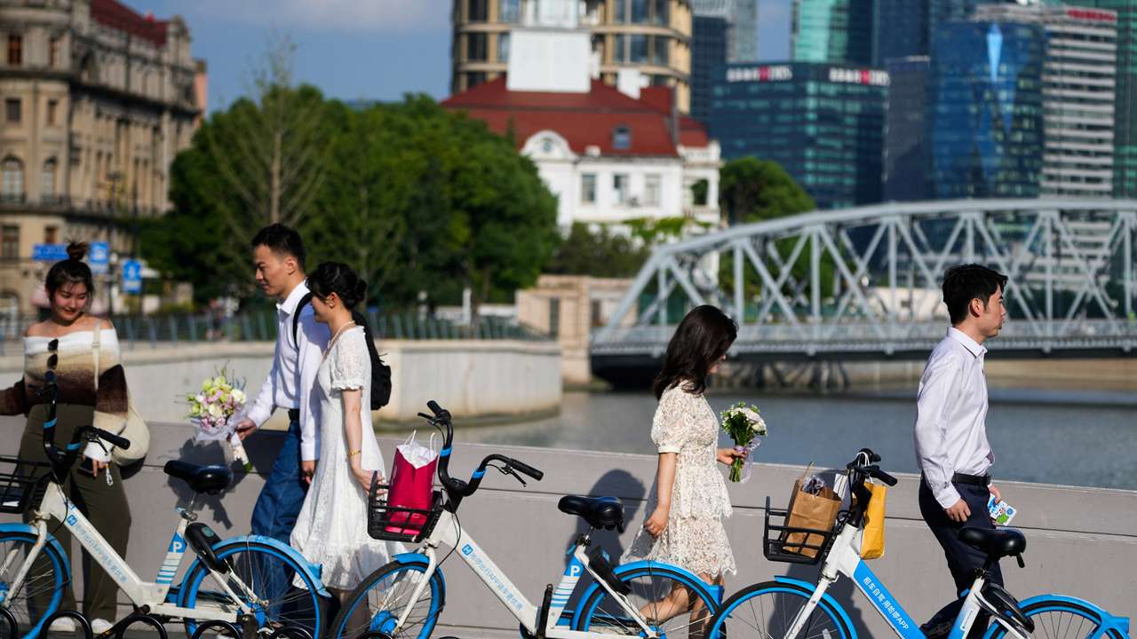 Couples prepare to get their photo taken during a wedding photography shoot on a street, in Shanghai