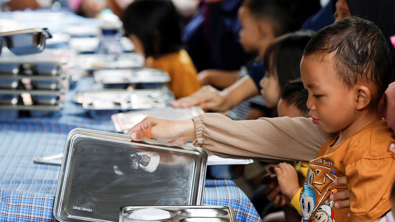 A boy reacts as he looks at his meal during the free nutritious meals program in Jakarta