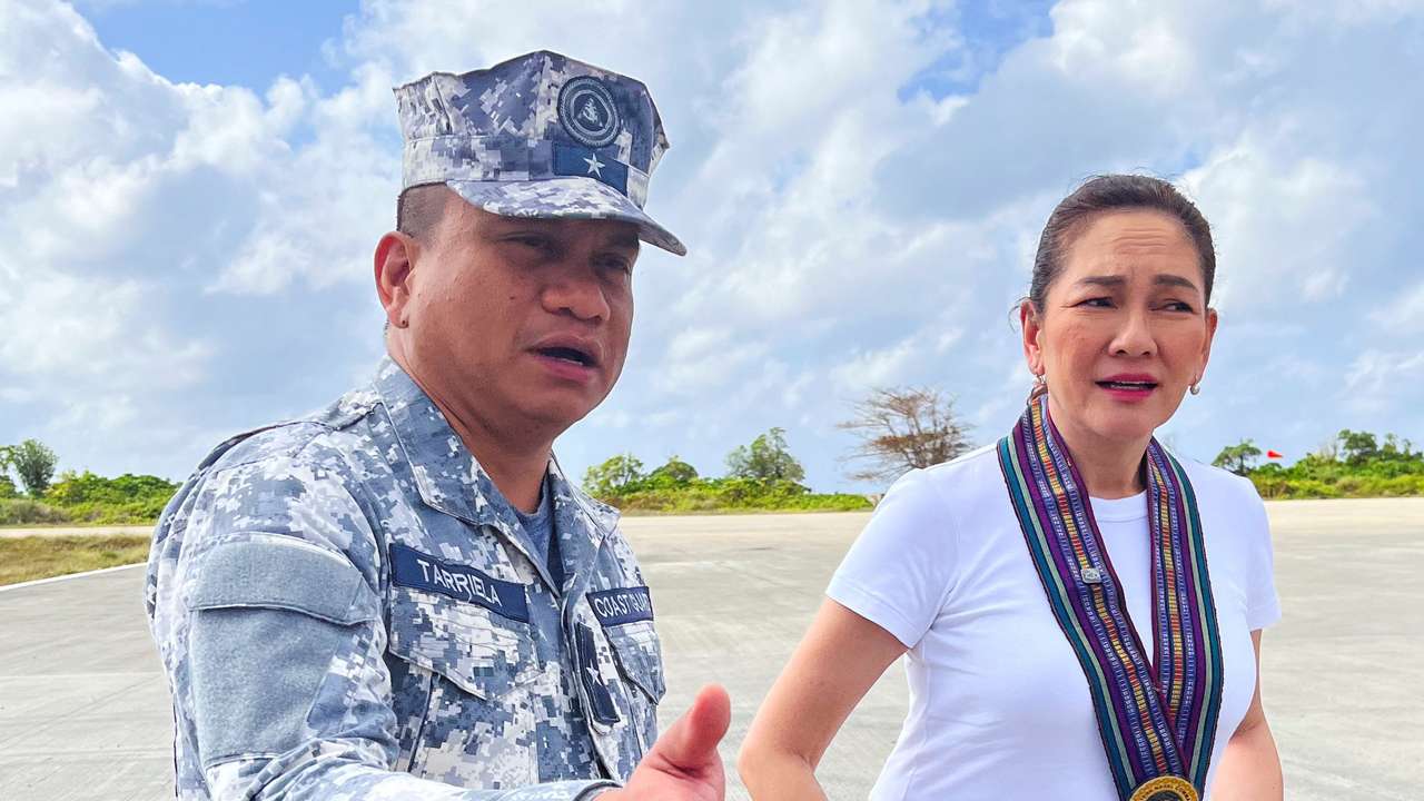Philippine Coast Guard spokesperson Commodore Jay Tarriela gestures beside Philippine Senator Risa Hontiveros during a visit to Philippine-occupied Thitu Island in the disputed South China Sea