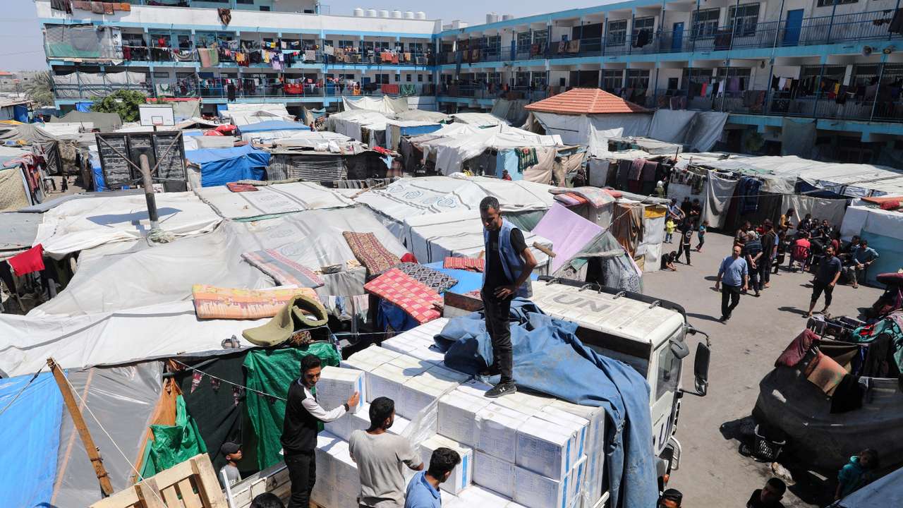 FILE PHOTO: Palestinians distribute aid at a shelter center in Deir Al-Balah