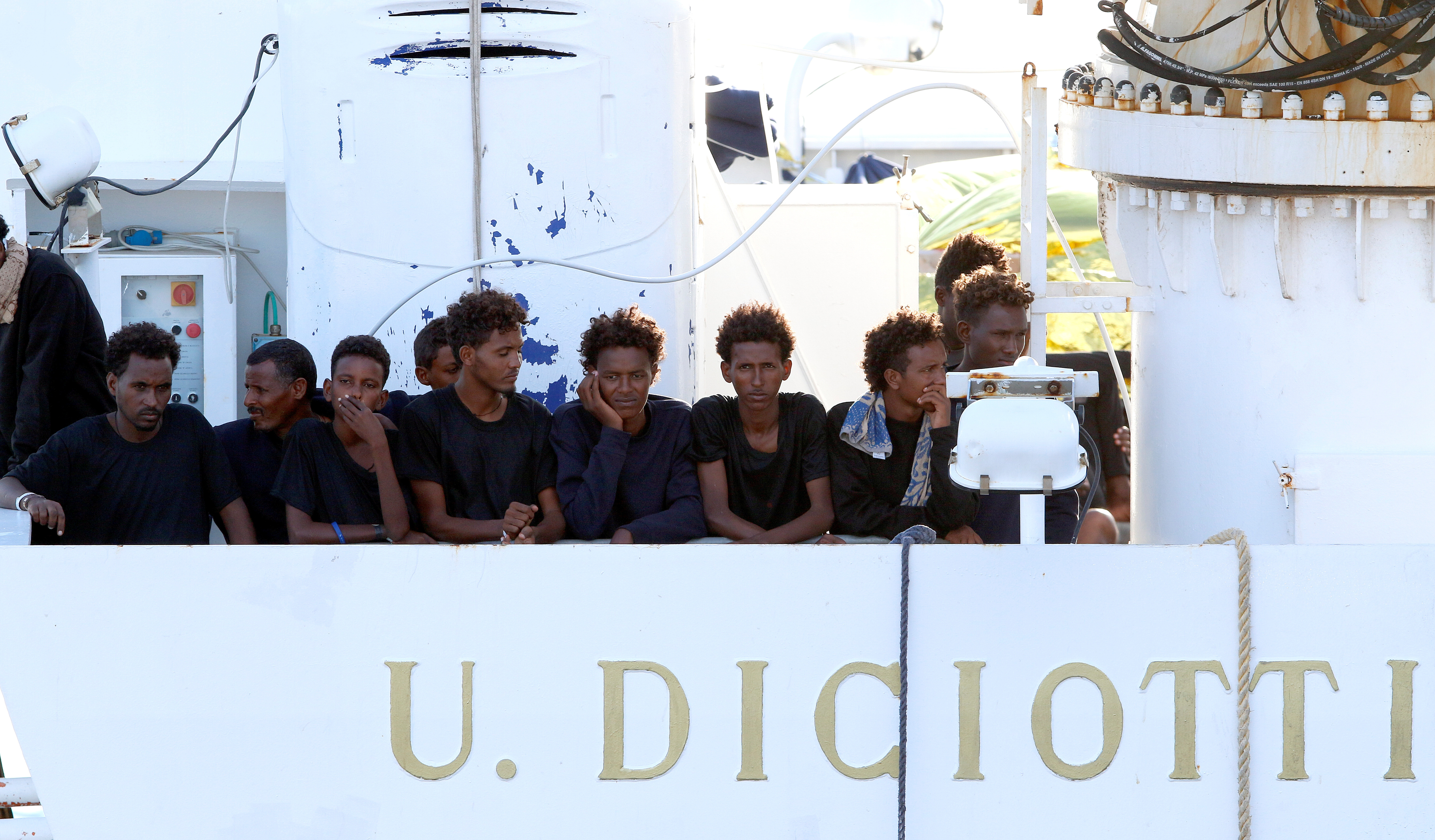 Migrants wait to disembark from the Italian coast guard vessel "Diciotti" at the port of Catania