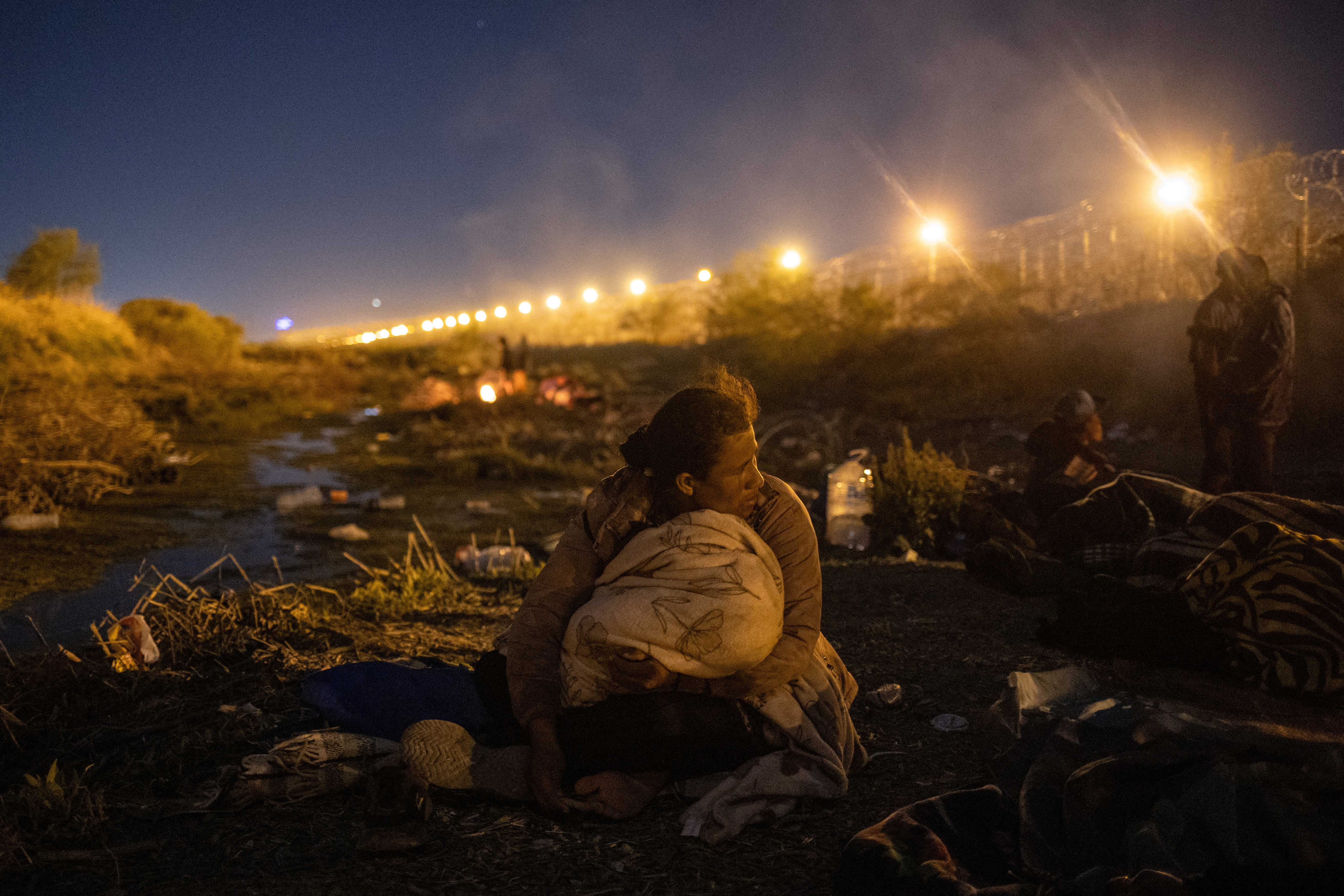 Migrant woman from Nicaragua looks towards the U.S. from the riverbed of the Rio Grande