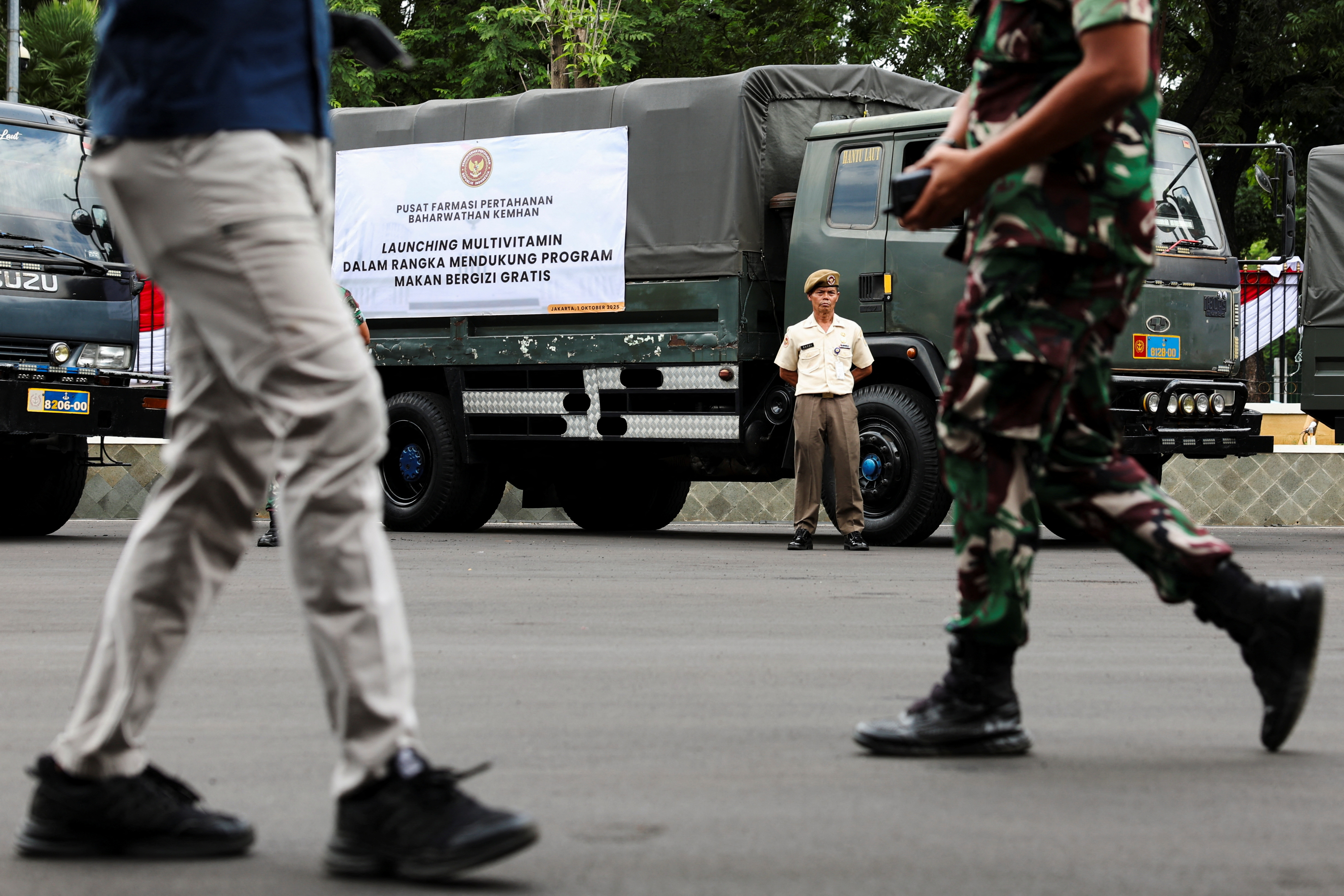 An Indonesian military officer stands beside a truck carrying multivitamins to be used in the government's free meal programme before launch in Jakarta