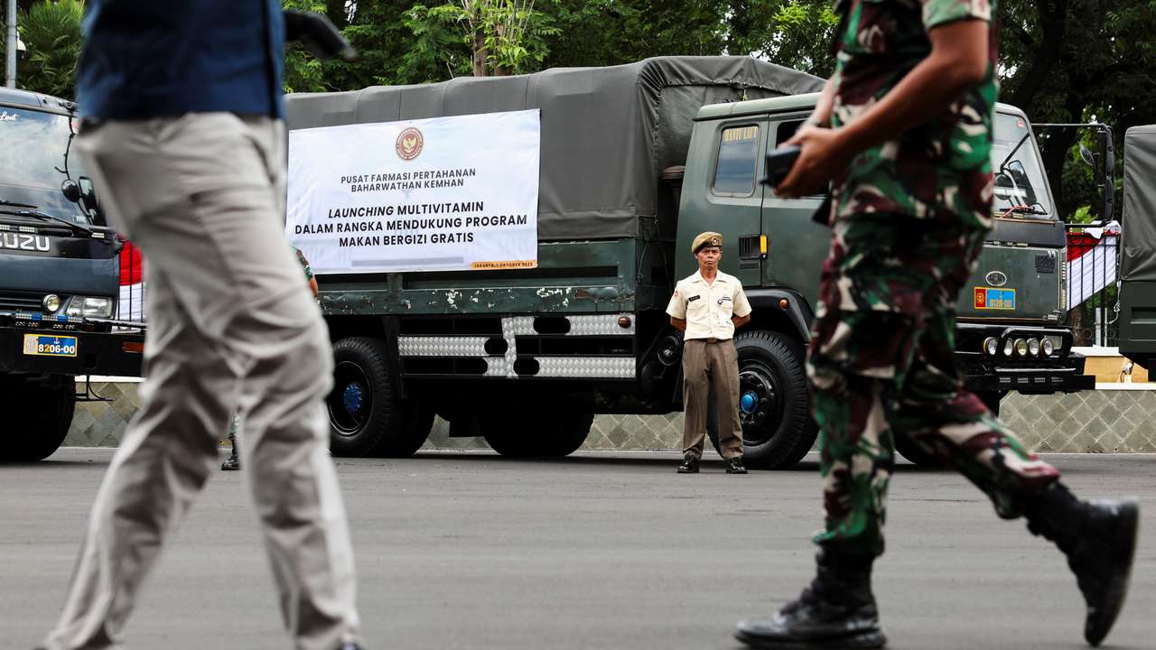 An Indonesian military officer stands beside a truck carrying multivitamins to be used in the government's free meal programme before launch in Jakarta